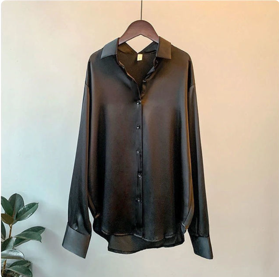 Schwarze Seidenbluse auf Holzkleiderbügel, langärmlig, glänzend, elegant. Perfekt für Damenmode, Bürooutfits, Abendgarderobe.