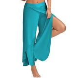 Frau trägt türkisfarbene, fließende Haremshose mit seitlichem Schlitz. Sommermode, Strandkleidung, bequeme Damenhose.