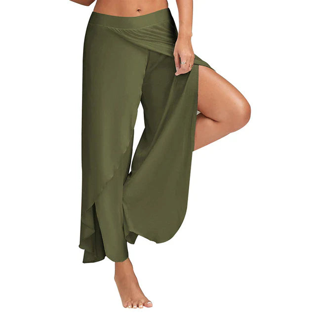 Frau trägt olivgrüne, fließende Haremshose mit seitlichem Schlitz, ideal für Yoga oder Freizeit. Bequeme Damenmode, trendige Sommerhose.