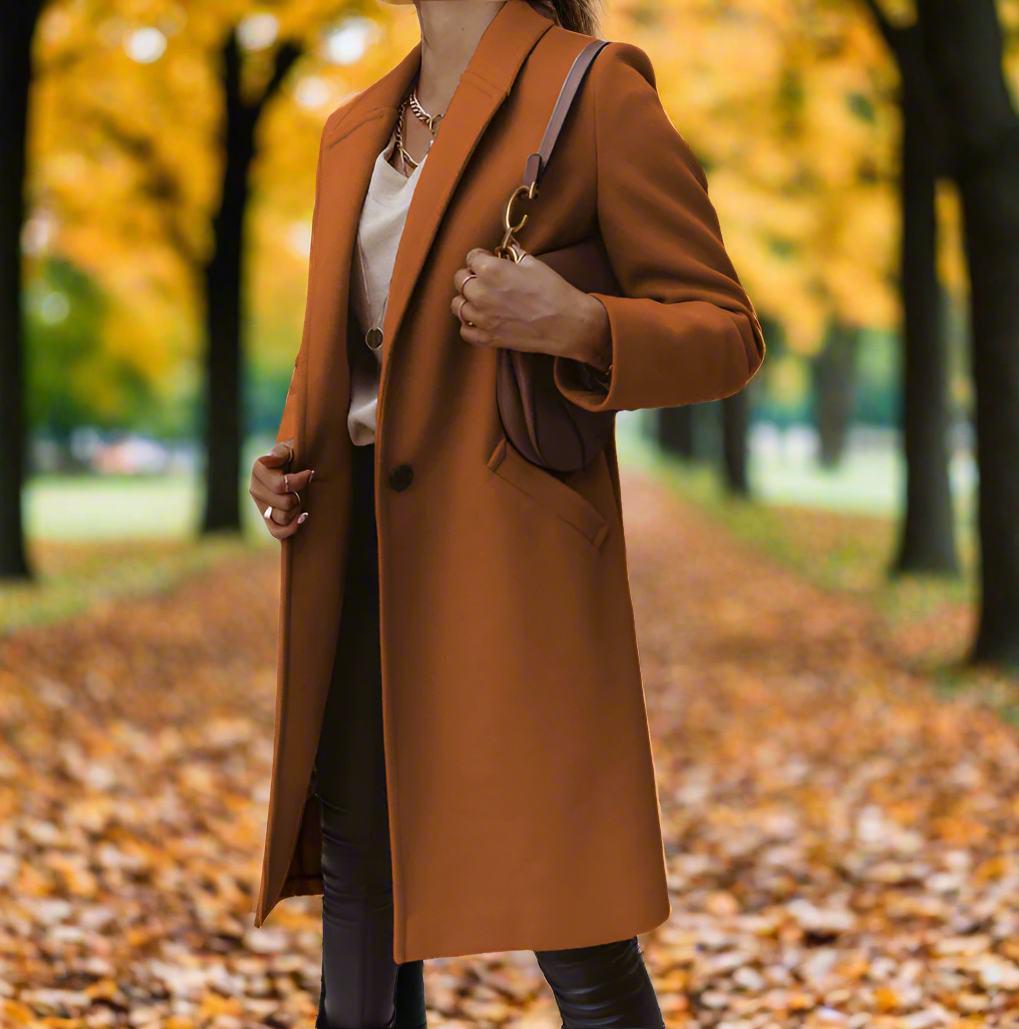 Frau im braunen Mantel im herbstlichen Park, umgeben von gelben Blättern. Herbstmode, stilvoller Mantel, Naturhintergrund, Spaziergang im Herbst.